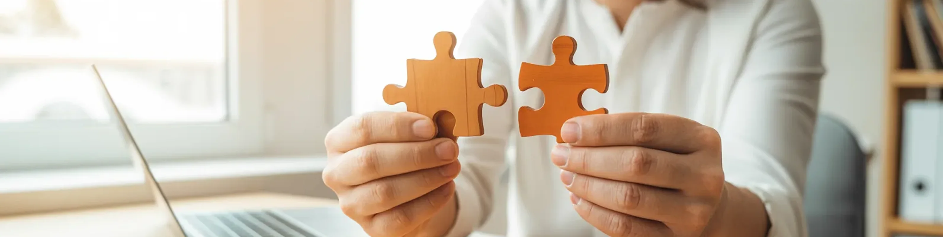 hands joining puzzle pieces